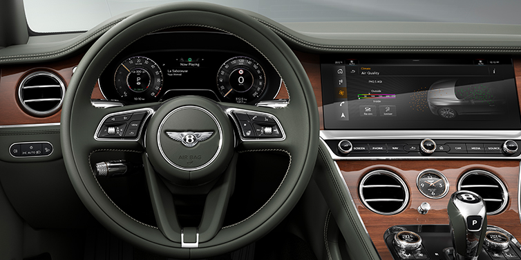 Bentley Manila New Bentley Continental GT coupe steering wheel and front cabin view in Cumbrian Green hide and Crown Cut walnut veneer